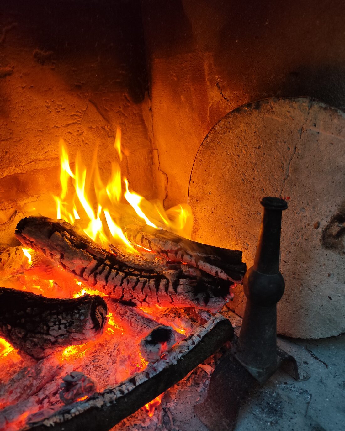Embers and flame in a stone fireplace