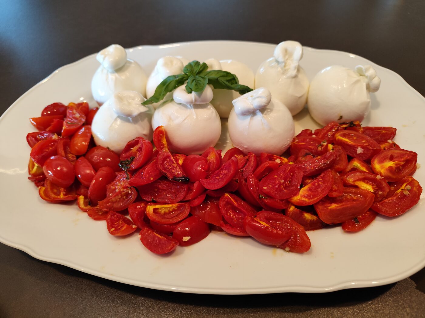 A platter of burrata and confit cherry tomatoes