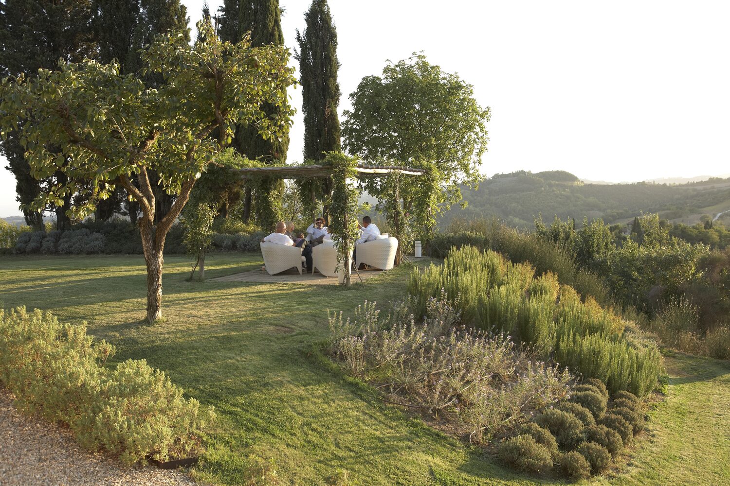 The garden of an Umbrian villa at dusk, set up for the evening