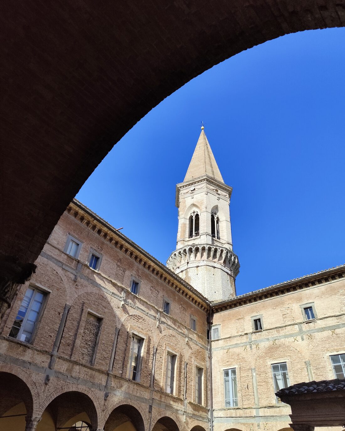 The bell tower of San Pietro in Perugia framed by an arch