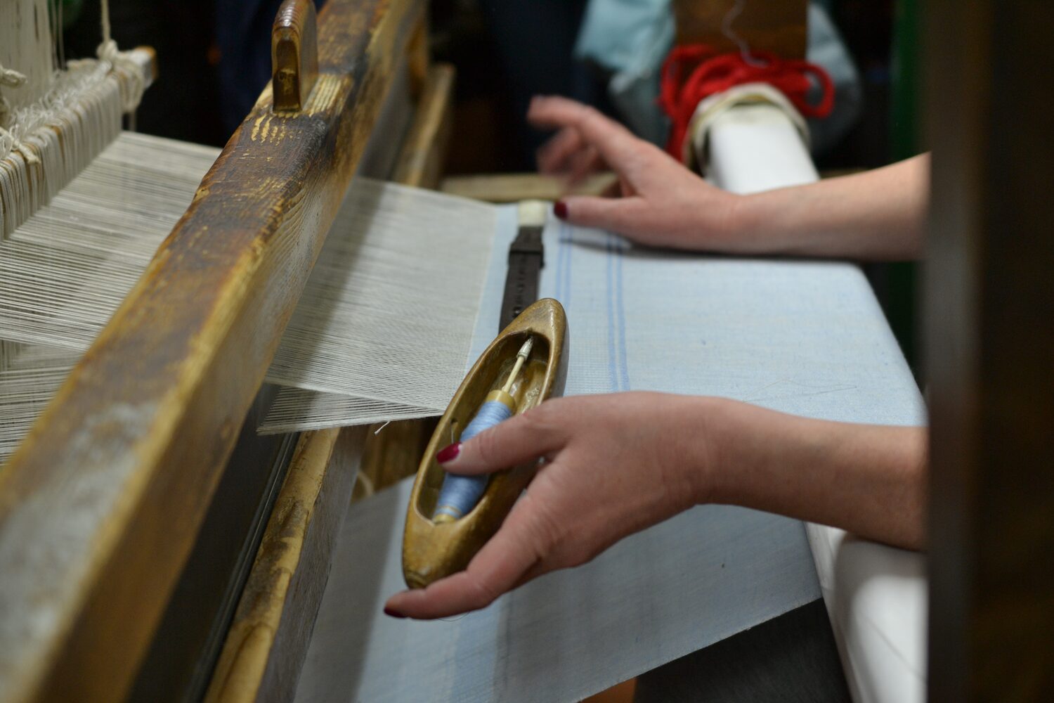 Hands at work on a hand loom in a Perugia weaving workshop