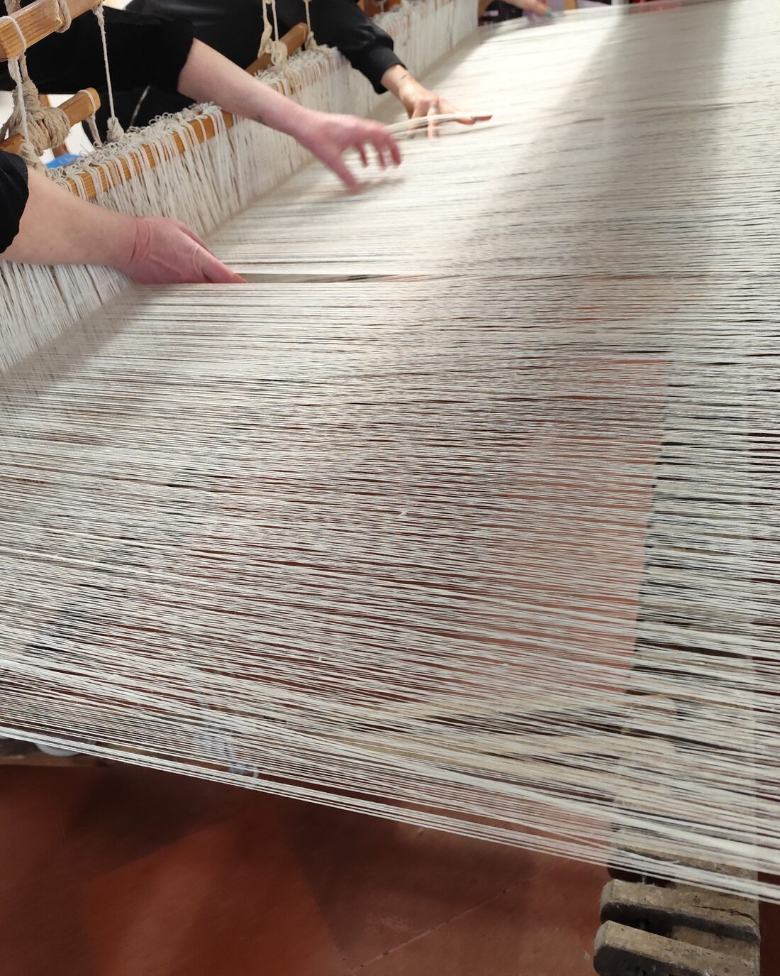 Warp threads stretched on a hand loom in a Perugia weaving workshop