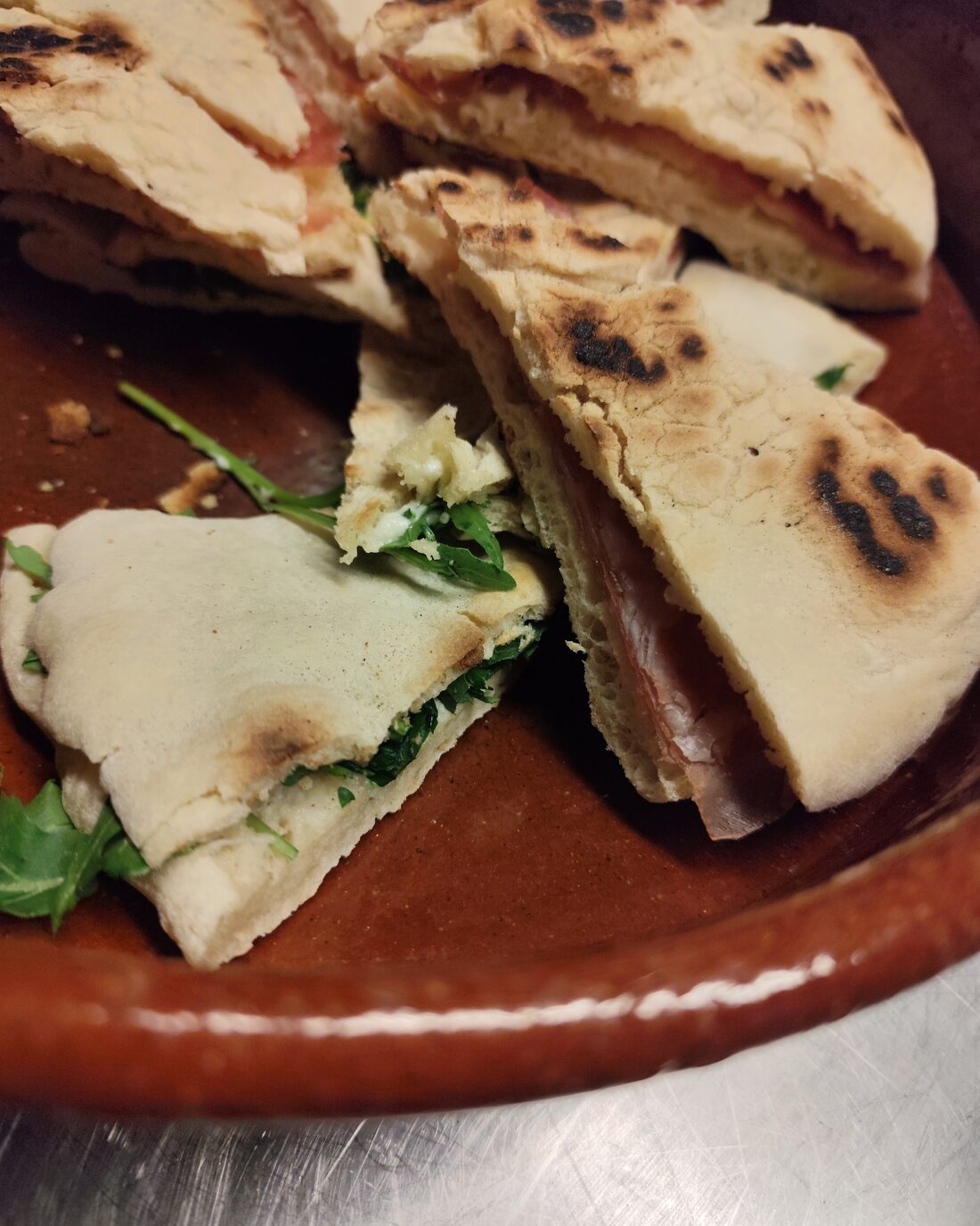 Wedges of filled torta al testo on a ceramic plate