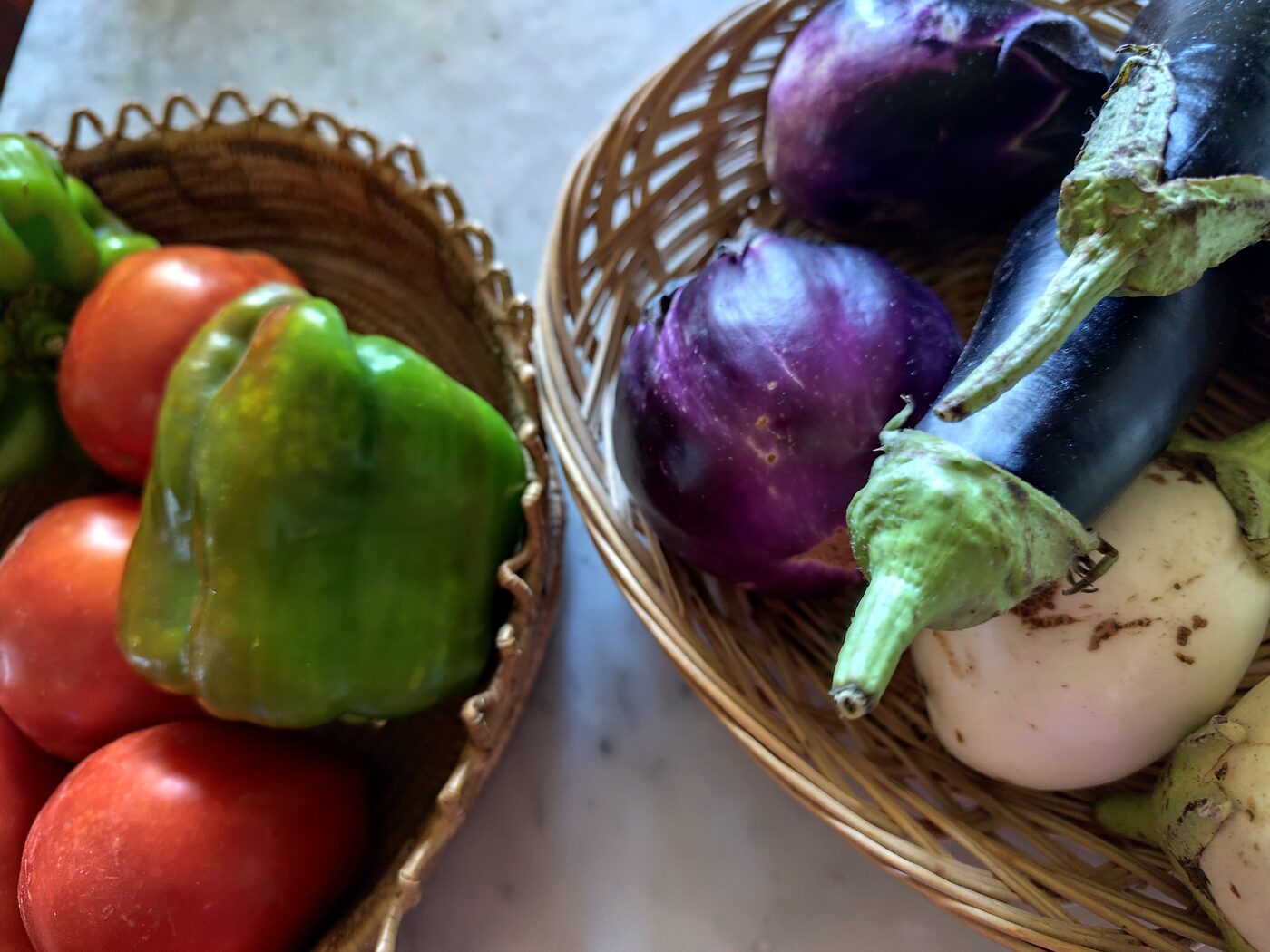 Peppers, aubergines and tomatoes in wicker baskets